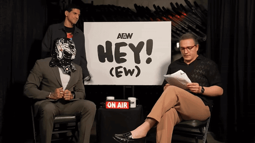 Two Men Sitting by Hey Sign
