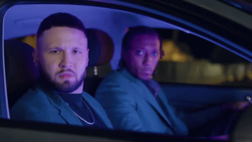 Two Men Sitting in Car at Night with Dreadlocks