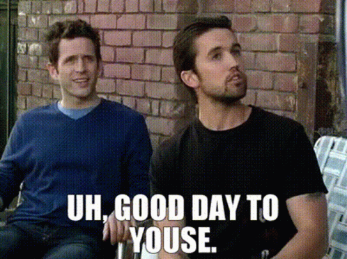 Two Men Sitting In Front Of Brick Wall Saying Uh Good Day To Youse GIF