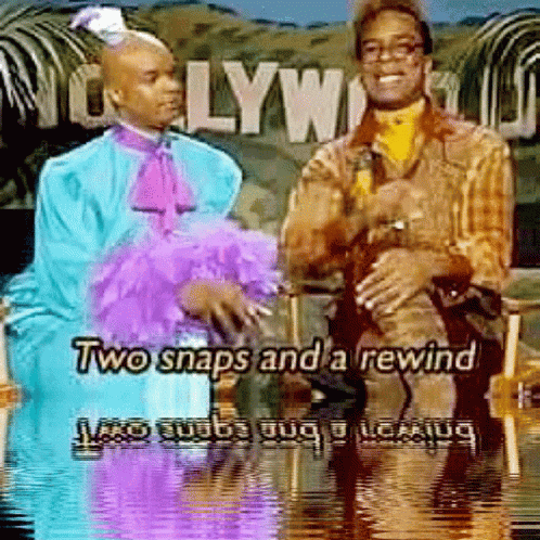 Two Men Sitting In Front Of Hollywood Sign GIF
