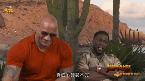 Two Men Sitting in Front of Jumanji Sign