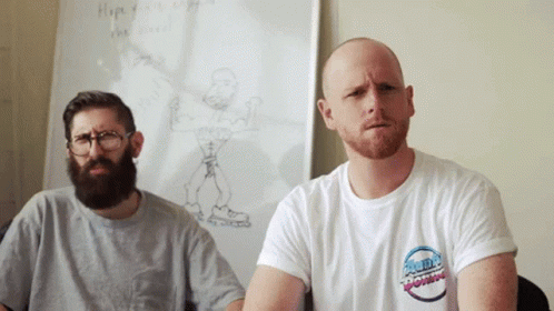 Two Men Sitting in Front of White Board With Drawing