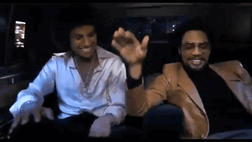 Two Men Sitting in Limousine One Wearing Sunglasses
