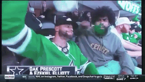 Two Men Sitting In Stadium With Dak Prescott & Ezekiel Elliott Sign GIF