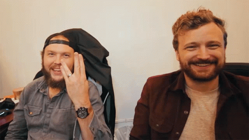 Two Men Sitting Next To Each Other One Wearing Watch
