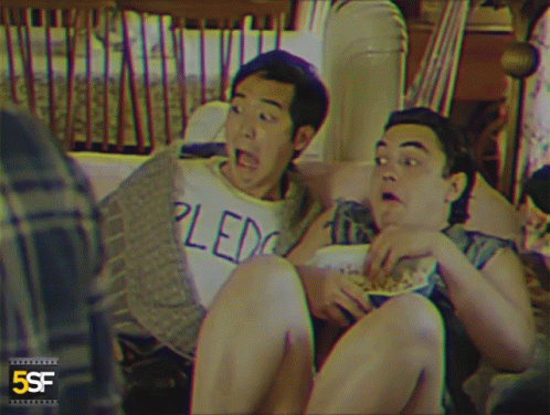 Two Men Sitting On Couch One In Pledge Shirt GIF