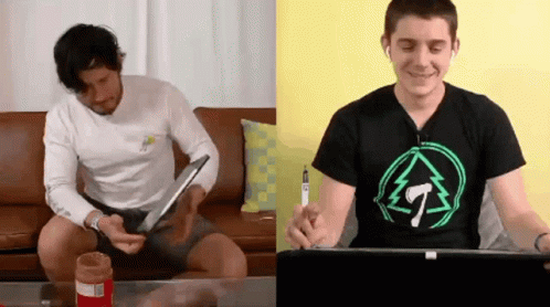 Two Men Sitting on Couch One Wearing T-Shirt