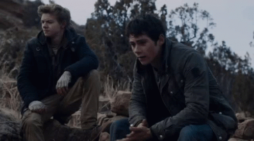 Two Men Sitting On Rocky Hillside Talking GIF