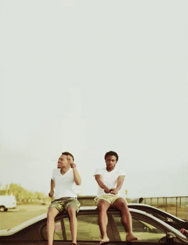 Two Men Sitting On The Roof Of A Car Drinking Beer GIF