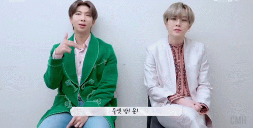 Two Men Sitting, One in Green Jacket
