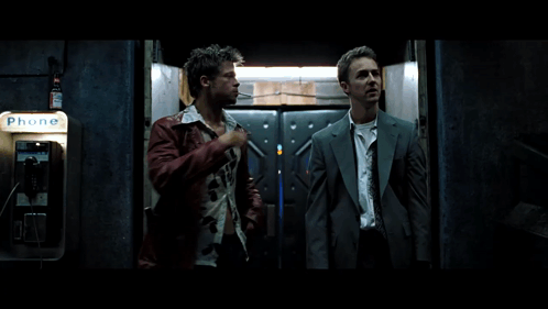 Two Men Stand In Front Of A Phone Booth That Says Phone GIF