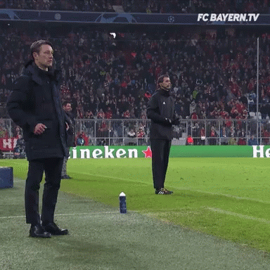 Two Men Stand On A Soccer Field In Front Of A Heineken Ad GIF