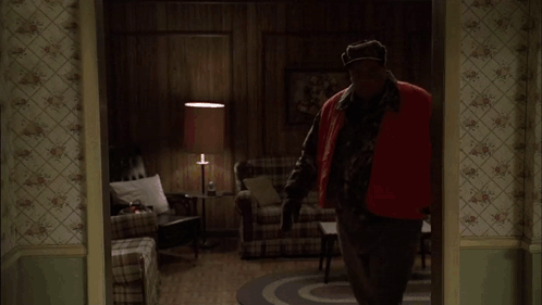 Two Men Standing In A Kitchen With A Bottle Of Liquor On The Counter GIF