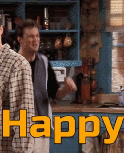 Two Men Standing In A Kitchen With The Word Happy Written In Orange GIF