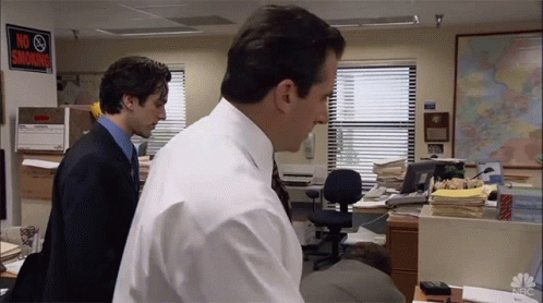 Two Men Standing In An Office With A No Smoking Sign On The Wall GIF