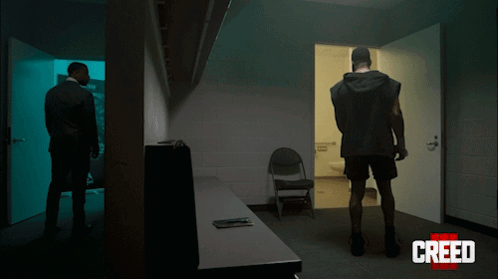 Two Men Standing in Dark Room