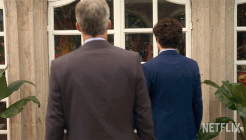 Two Men Standing In Front Of A Building With A Netflix Logo On The Bottom GIF
