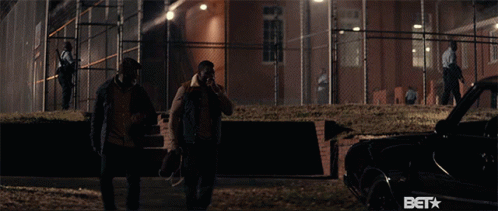 Two Men Standing In Front Of A Fence With The Word Bet On The Bottom GIF
