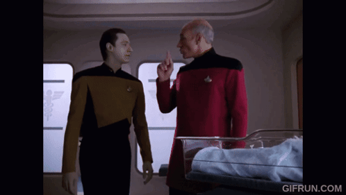 Two Men Standing in Front of Baby in Crib