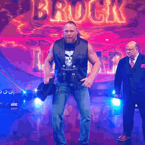 Two Men Standing In Front Of Brock Sign GIF