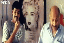 Two Men Standing in Front of Madonna Painting