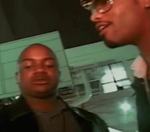 Two Men Standing Next to Each Other in Front of Building