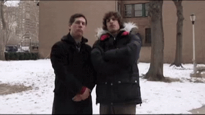 Two Men Standing Next To Each Other In The Snow . GIF