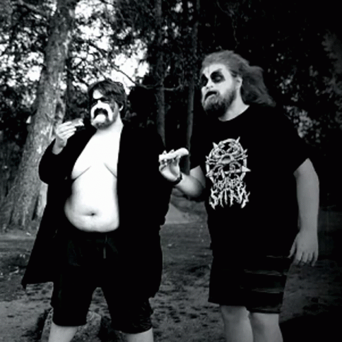 Two Men Standing Next To Each Other One Wearing A T-Shirt That Says Broken Silly GIF