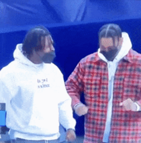 Two Men Standing Next To Each Other One Wearing A White Hoodie And The Other A Red Plaid Shirt GIF
