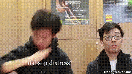 Two Men Standing Next to Each Other One Wearing Glasses Covering Face