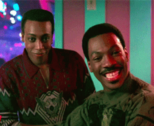 Two Men Standing Next to Each Other Smiling