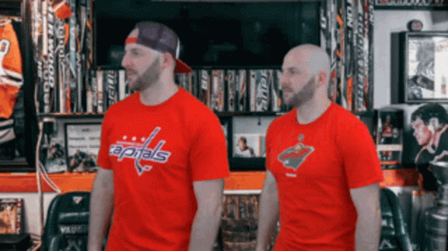 Two Men Standing Next To Each Other Wearing Red Capitals T-Shirts GIF