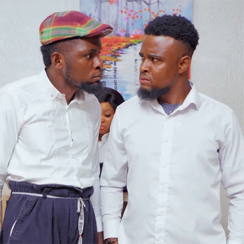Two Men Standing Next To Each Other With One Wearing A Plaid Hat And The Other Wearing White Shirts GIF