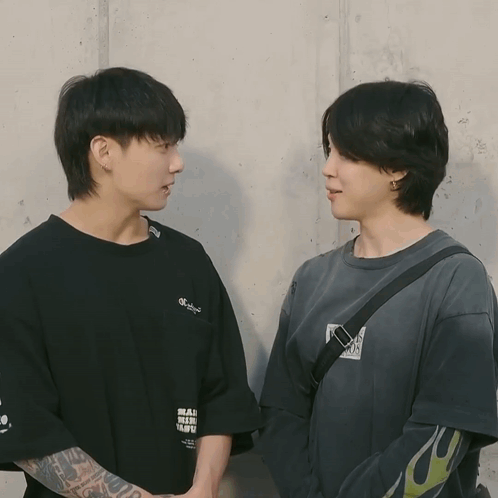 Two Men Standing Next To Each Other With One Wearing A T-Shirt That Says Mad Genius GIF