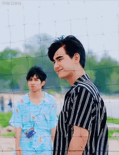 Two Men Standing Next To Volleyball Net GIF