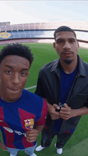 Two Men Standing On A Soccer Field With One Wearing A Shirt That Says Sport GIF