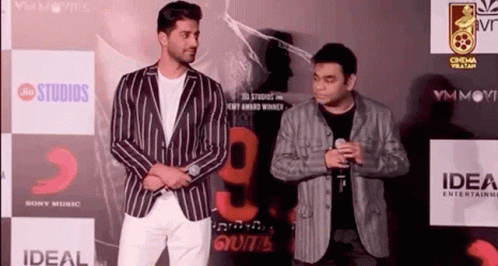Two Men Standing on Red Carpet
