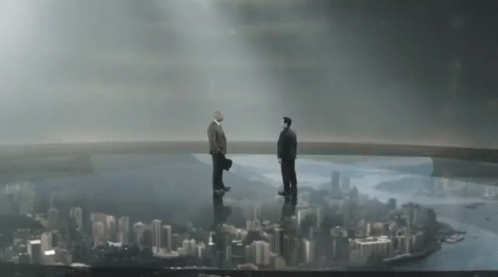 Two Men Standing On Top Of A Bridge Overlooking A City Skyline GIF