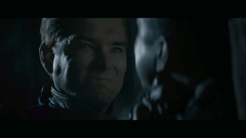 Two Men Staring in Dark One Smiling