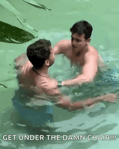 Two Men Swimming in Pool Get Under the Damn Chair