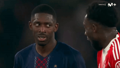 Two Men Talking Before Screen Saying Directo M + GIF