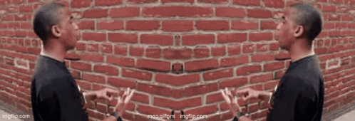 Two Men Talking Beside Red Brick Wall