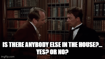 Two Men Talking In Front Of Bookshelf GIF