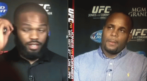 Two Men Talking in Front of UFC Sign