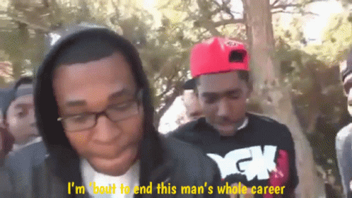 Two Men Talking, One in Hoodie and YCK Shirt