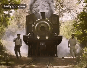 Two Men Walking in Front of a Train