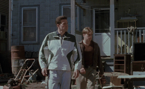 Two Men Walking In Front Of Lawn Mower GIF