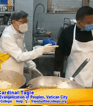 two men wearing aprons and face masks cooking in a kitchen