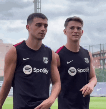 two men wearing black spotify shirts stand next to each other