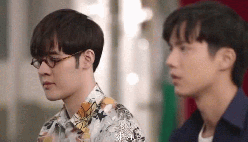 Two Men Wearing Glasses Are Standing Next To Each Other And Looking At Each Other . GIF